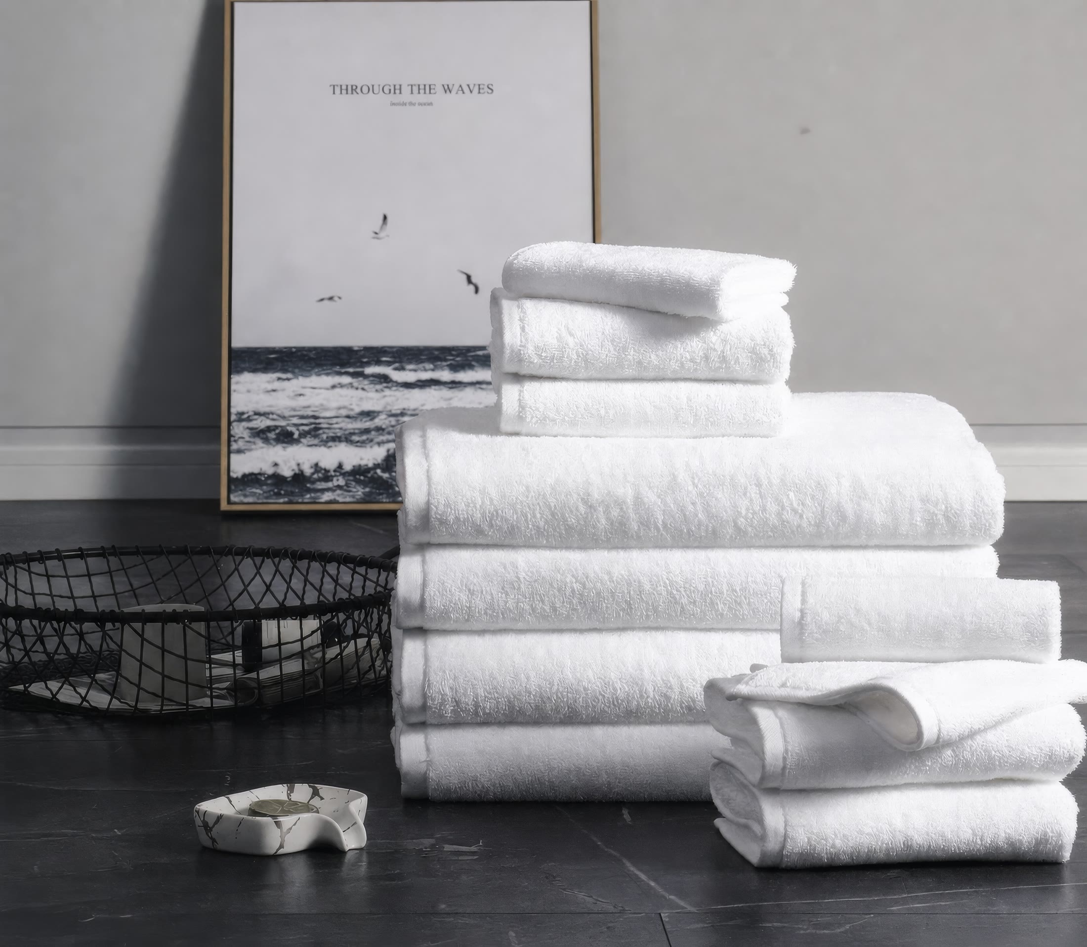 Folded white bath towels stacked in a calm bathroom setting