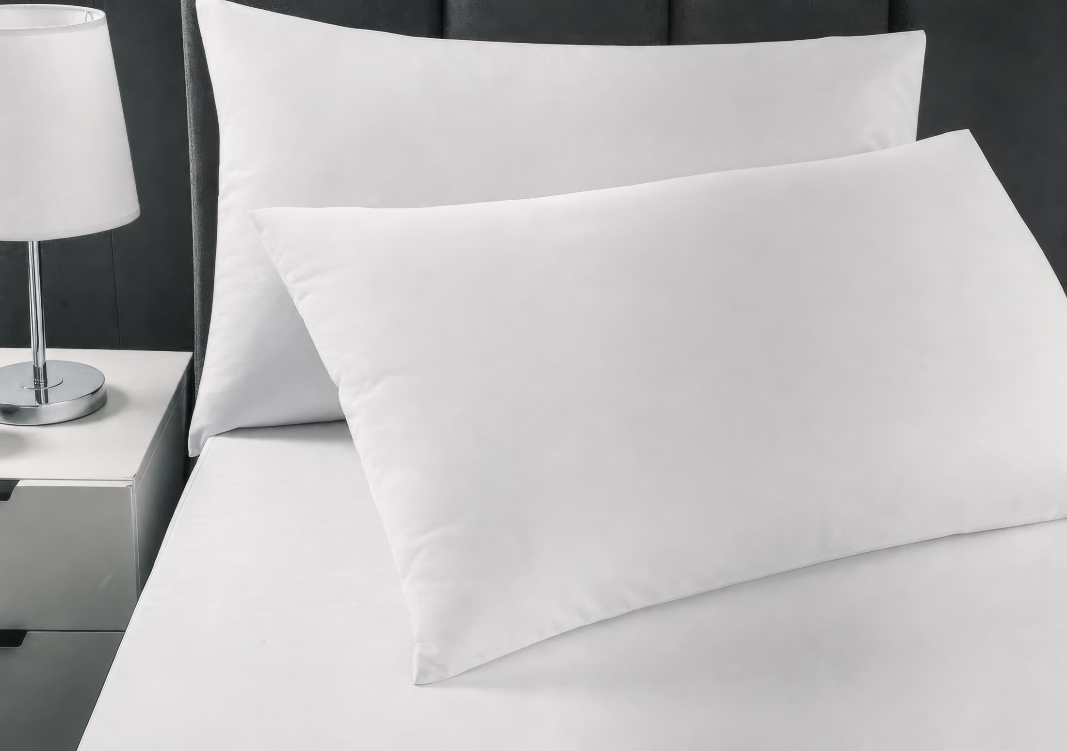 White pillow protectors and covers styled on a hotel bed